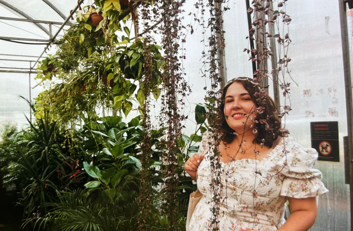 A portrait of Megan Hunt in a garden centre.